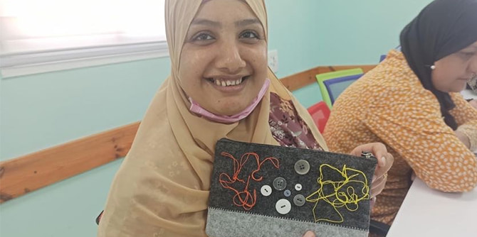 A woman shows a laptop sleeve that she made (Photo courtesy of Michal Sadeh-Goldvasser and Celia Jubari)